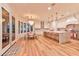 Bright kitchen boasts wood floors, white cabinets, marble counters, large island, and chandelier at 7565 N Torrey Pines Dr # A, Las Vegas, NV 89131