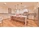 Bright kitchen features wood floors, white cabinets, marble counters, and large island at 7565 N Torrey Pines Dr # A, Las Vegas, NV 89131