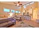 Open-concept living space with windows, ceiling fan, and kitchen featuring stainless steel appliances and granite countertops at 7565 N Torrey Pines Dr # A, Las Vegas, NV 89131