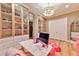 Bright walk-in closet featuring glass cabinets, desk, and hardwood floors at 7565 N Torrey Pines Dr # A, Las Vegas, NV 89131