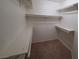 Walk-in closet with carpet and built-in shelves and rods for organized storage at 8455 W Sahara Ave # 226, Las Vegas, NV 89117