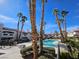 Resort-style pool with clear blue water, surrounded by palm trees and landscaping at 8455 W Sahara Ave # 226, Las Vegas, NV 89117
