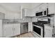 Well-lit kitchen features modern appliances, granite counters and white shaker cabinets at 9050 W Warm Springs Rd # 2153, Las Vegas, NV 89148