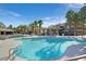 Beautiful pool with clear water, palm trees, lounge chairs, and nearby buildings at 9050 W Warm Springs Rd # 2153, Las Vegas, NV 89148