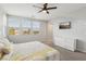 A spacious bedroom with a ceiling fan, large windows, and neutral decor at 9690 Hiking Ave, Las Vegas, NV 89166