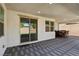 Covered patio with gray brick floor, recessed lighting, and sliding glass doors to the backyard at 9690 Hiking Ave, Las Vegas, NV 89166