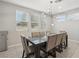 Contemporary dining area with modern chandelier, tile flooring, and ample natural light at 9690 Hiking Ave, Las Vegas, NV 89166