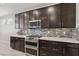 Well-equipped kitchen with stainless steel appliances, granite countertops, and dark wood cabinets at 9690 Hiking Ave, Las Vegas, NV 89166