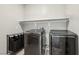 Bright laundry room features modern washer and dryer, with ample shelf storage at 9690 Hiking Ave, Las Vegas, NV 89166