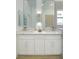 Bathroom featuring dual sinks, modern mirrors and light fixture, with updated vanity at 9741 Panorama Cliff Dr, Las Vegas, NV 89134