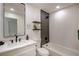 Bathroom features modern fixtures, a soaking tub, an accent wall, and a vanity with white marble countertop at 9741 Panorama Cliff Dr, Las Vegas, NV 89134