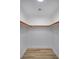 White walk-in closet with laminate floors, white trim, and hanging rods for storage at 9741 Panorama Cliff Dr, Las Vegas, NV 89134