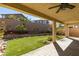 Inviting backyard with covered patio, artificial turf, rock features, and mature landscaping at 981 Soaring Moon Dr, Henderson, NV 89015