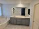 Bathroom with double sink vanity, soaking tub, tile floor, and shower with glass door at 981 Soaring Moon Dr, Henderson, NV 89015