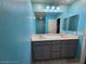 Bright bathroom with double sink vanity, gray cabinets, recessed lighting, and tile floors at 981 Soaring Moon Dr, Henderson, NV 89015