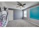 Bedroom featuring gray carpet, ceiling fan, accent wall, and natural light at 981 Soaring Moon Dr, Henderson, NV 89015