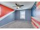 Quaint bedroom with designer accent wall, ceiling fan, and window with blinds at 981 Soaring Moon Dr, Henderson, NV 89015