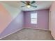 Bright bedroom with designer painted accent wall, gray carpet, ceiling fan, and window at 981 Soaring Moon Dr, Henderson, NV 89015
