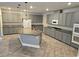 Spacious kitchen features gray cabinets, a granite island, and modern stainless steel appliances at 981 Soaring Moon Dr, Henderson, NV 89015