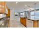 A view of the kitchen island flowing into the living room with fireplace and television at 981 Soaring Moon Dr, Henderson, NV 89015