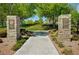 Stone pillars mark the entrance to The Gardens Park, showcasing beautiful landscaping and a welcoming path at 10397 Walking View Ct, Las Vegas, NV 89135