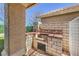 Outdoor kitchen featuring brick and tile with a barbeque grill and concrete pillar at 105 Eagleview Ct, Henderson, NV 89074