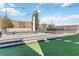 Modern backyard featuring artificial turf, a fire pit with seating, and a hot tub for relaxation at 11548 Salt Creek Ave, Las Vegas, NV 89138