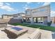 Backyard with artificial turf, patio, fire pit, outdoor seating, and barbecue area at 11548 Salt Creek Ave, Las Vegas, NV 89138