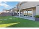 A lush backyard with artificial turf, patio, and a covered outdoor seating area with string lights at 11548 Salt Creek Ave, Las Vegas, NV 89138