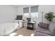 Bedroom with large windows, a bed, a desk setup, and cozy sofa offers a versatile and comfortable space at 11548 Salt Creek Ave, Las Vegas, NV 89138