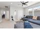 Bright living room featuring a comfortable couch, soft carpet, and modern ceiling fan at 11548 Salt Creek Ave, Las Vegas, NV 89138