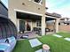 Inviting covered back patio with brick pavers and artificial turf at 12451 Island Bells Ave, Las Vegas, NV 89138