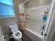 Bathroom featuring a shower and tub combination with white tile surround, and a toilet with seat up at 12451 Island Bells Ave, Las Vegas, NV 89138