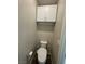 Small toilet room area with sleek white toilet and convenient overhead storage at 12451 Island Bells Ave, Las Vegas, NV 89138