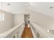 Upstairs hallway featuring hardwood floors, natural light, and white railing detail at 1708 Imperial Cup Dr, Las Vegas, NV 89117