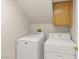 A functional laundry area with a washing machine and dryer set, plus overhead storage cabinet at 1708 Imperial Cup Dr, Las Vegas, NV 89117