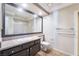 Bathroom features a sink with granite counters, a large mirror, and a shower with glass doors at 1804 Michael Ct, Henderson, NV 89014