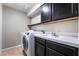 Modern laundry room with tile flooring, front loading washer and dryer, and updated cabinets at 1804 Michael Ct, Henderson, NV 89014
