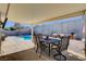 Covered patio area featuring an outdoor dining set with clear views of the pool at 216 Candlelight St, Las Vegas, NV 89145