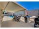 Covered patio area features a grill, outdoor furniture, and lounging area with a clear view of the pool at 216 Candlelight St, Las Vegas, NV 89145