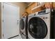 This laundry room includes a modern washer and dryer with storage above at 2255 Scena Ct, Henderson, NV 89052