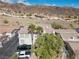 Aerial view of townhomes with palm trees and mountain views with vehicles in the driveway at 262 Big Horn Dr, Boulder City, NV 89005
