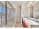 Bathroom with dual sinks, granite counters, and glass-enclosed shower and tub at 3550 Bay Sands Dr # 2087, Laughlin, NV 89029