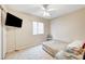 Neutral bedroom features a TV, ceiling fan, window, and tile flooring at 3650 Spring Willow Ct, Las Vegas, NV 89147