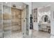 Beautiful glass shower with stone tile and pebble floor, accompanied by vanity and custom wall art at 431 Tranquil Peak Ct, Henderson, NV 89012
