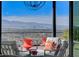 Outdoor patio with comfortable seating, orange accents, and a breathtaking view of the city skyline at 431 Tranquil Peak Ct, Henderson, NV 89012