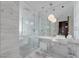 Modern bathroom with marble walls, glass shower, and dual sinks with sleek fixtures at 4381 W Flamingo Rd # 2712, Las Vegas, NV 89103