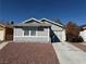 A well kept single story home with light gray exterior paint and reddish brown landscaping at 4661 Hutchinson Dr, Las Vegas, NV 89147