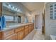 Bathroom featuring double sinks, granite countertops, vanity lighting, and a glass block window at 5071 Andover Ct, Pahrump, NV 89061