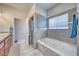 Well-lit bathroom featuring a soaking tub, tiled walls, and a separate shower at 5071 Andover Ct, Pahrump, NV 89061